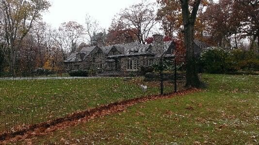 Professional non-electric fence installation on a modern residential property with green lawn